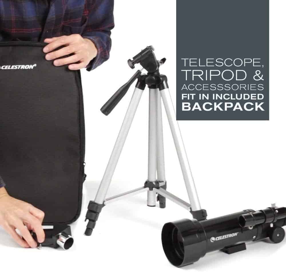 A man is holding a Celestron tripod and a backpack.