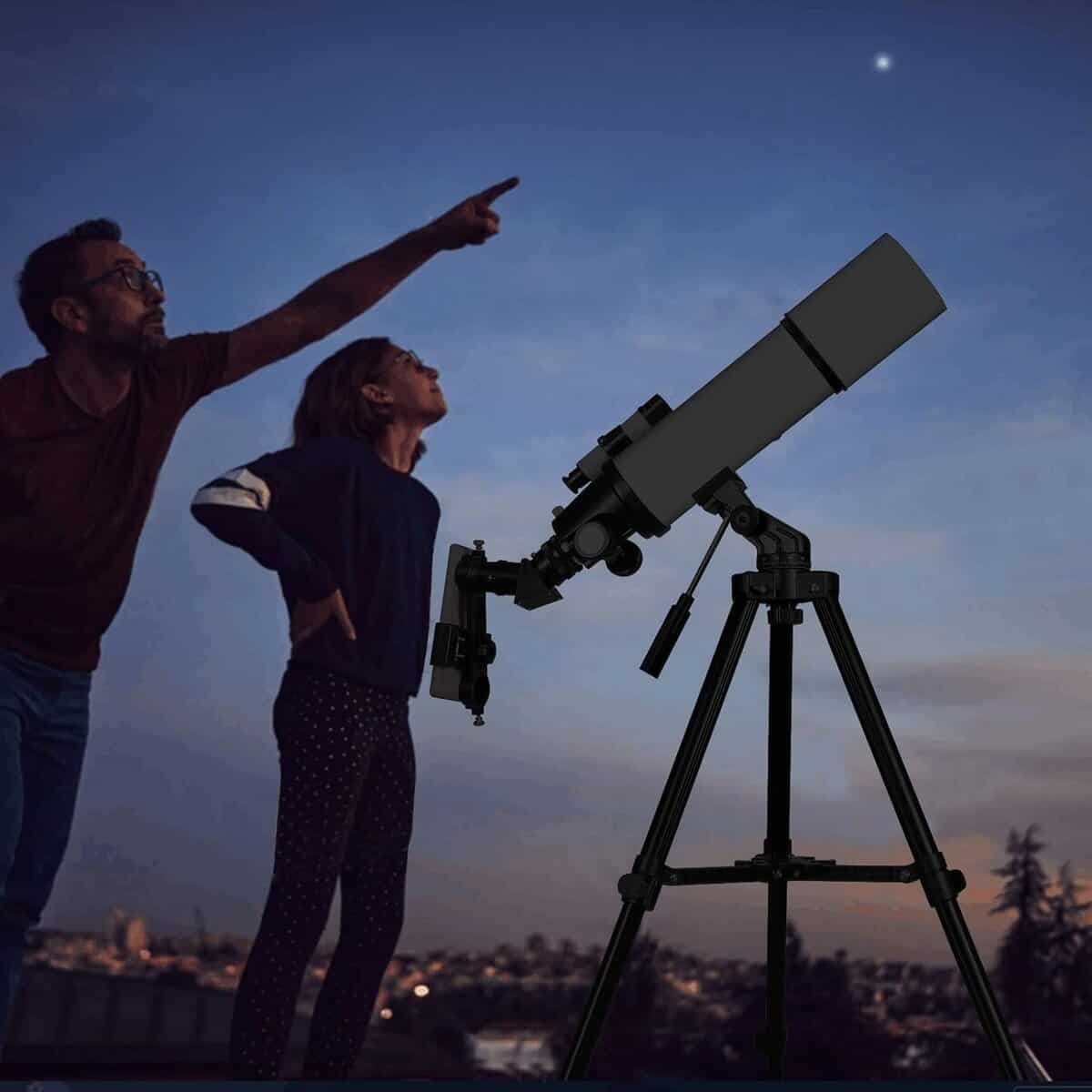 Two adults observing the stars with a telescope.