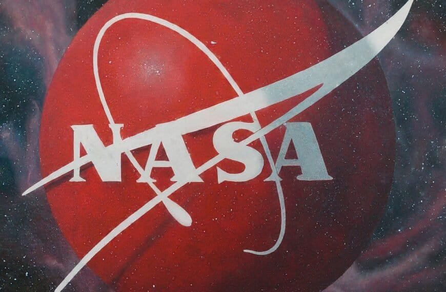 NASA in white font over a large red sphere with a white orbital path, set against a space-themed background with stars and nebulae, inspiring dreams of becoming an astronaut.