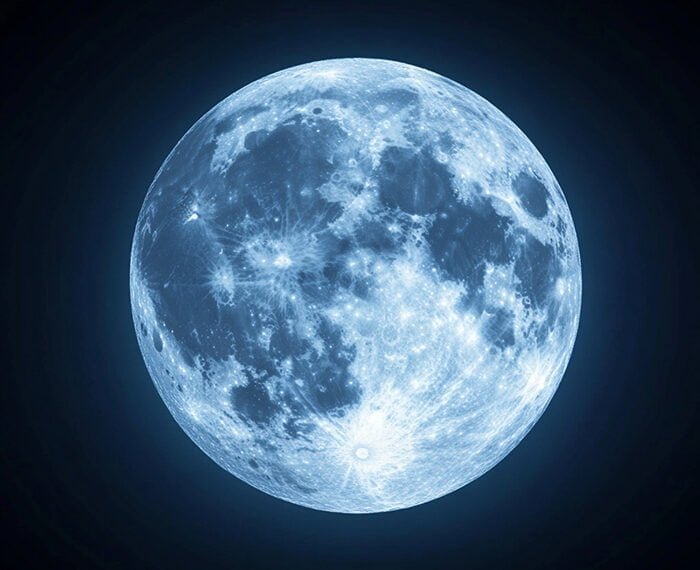 A detailed image of the blue moon against a dark sky, showing craters and surface markings illuminated in a bluish hue.
