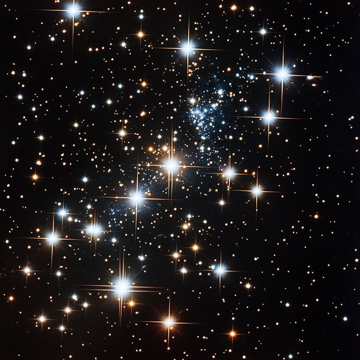 A dense cluster of bright stars on a dark background, with some stars emitting notable light flares, showcasing a vast, starry space scene. The twelve stars stand out prominently, adding both celestial splendor and symbolic meaning to the night sky.