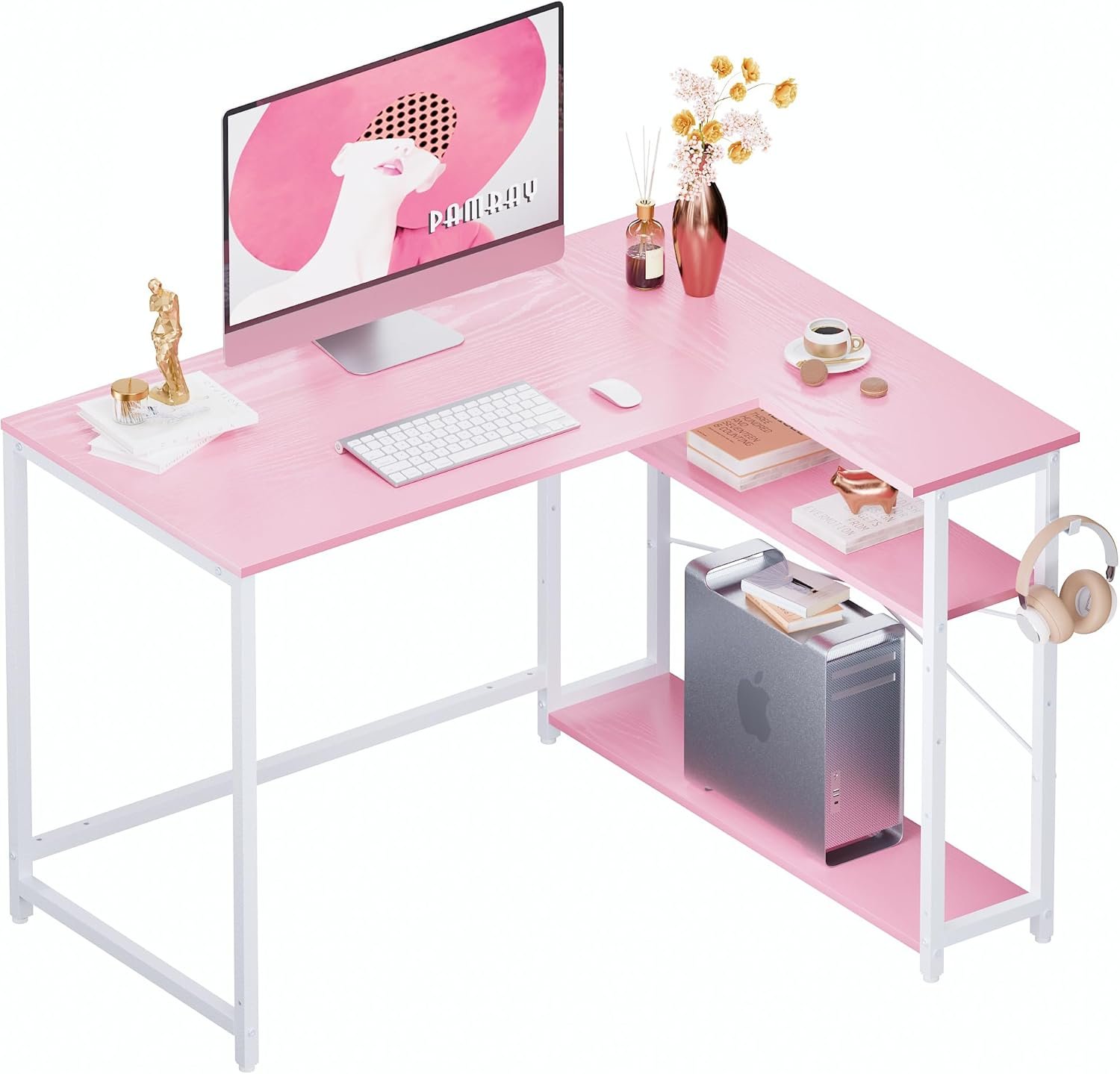 A pink and white desk with a computer setup. It includes a monitor, keyboard, mouse, potted plant, lamp, small statue, books, and headphones. The desk has shelves holding a computer tower and other items.