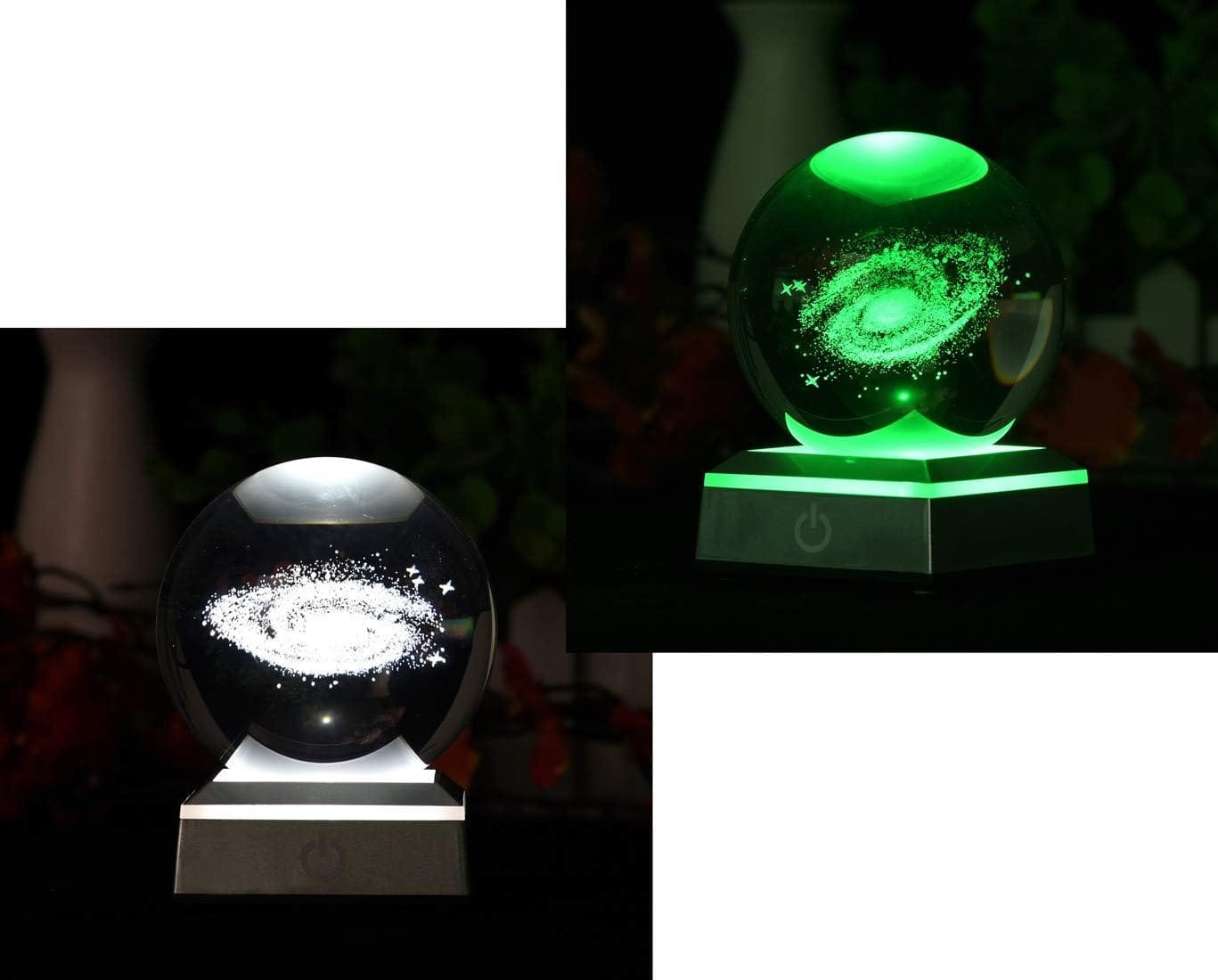 Glass sphere with galaxy design on a lit base; left image shows white light, right shows green light.