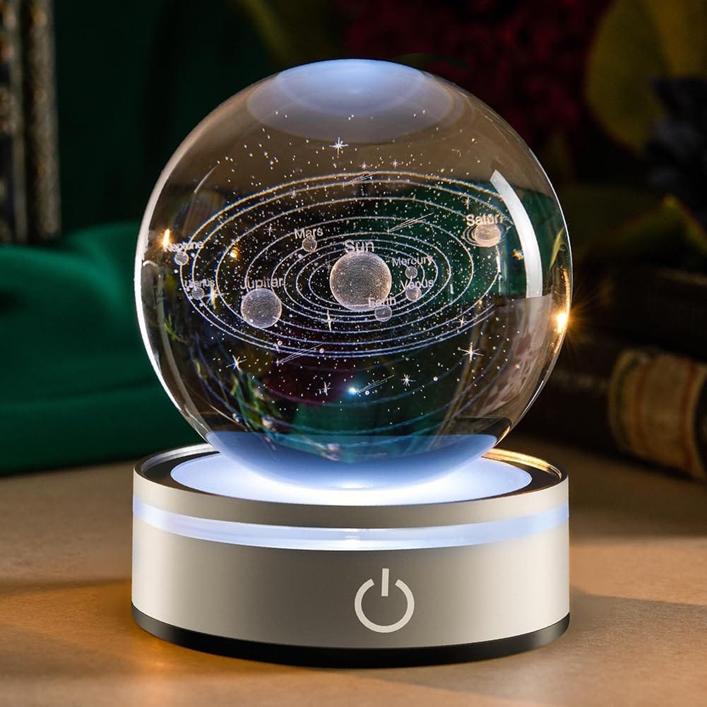 A glass globe displaying a 3D solar system model rests on an illuminated base with a power symbol.