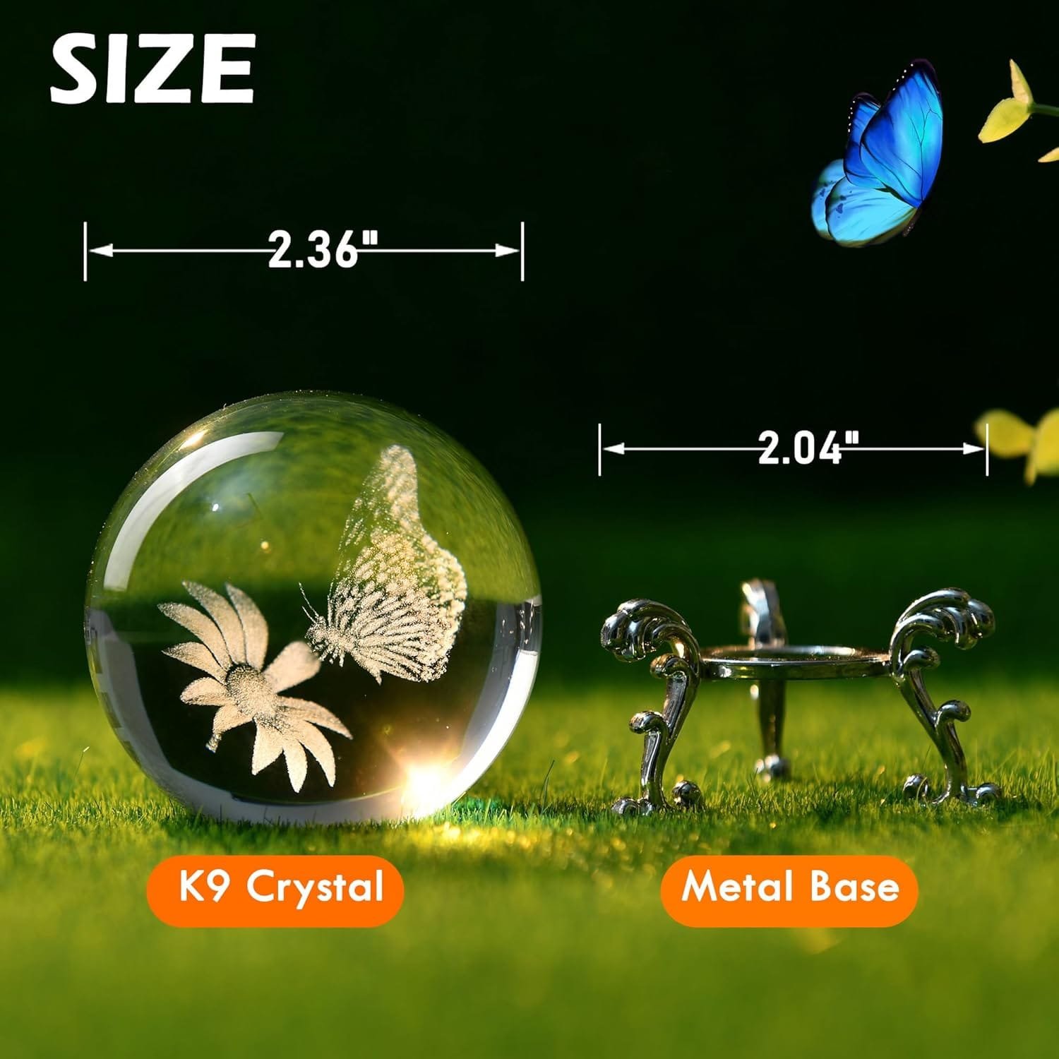 K9 crystal ball with a 3D butterfly and flowers on a grass surface, next to a metal base. Dimensions shown: ball 2.36" and base 2.04". A butterfly is flying nearby.
