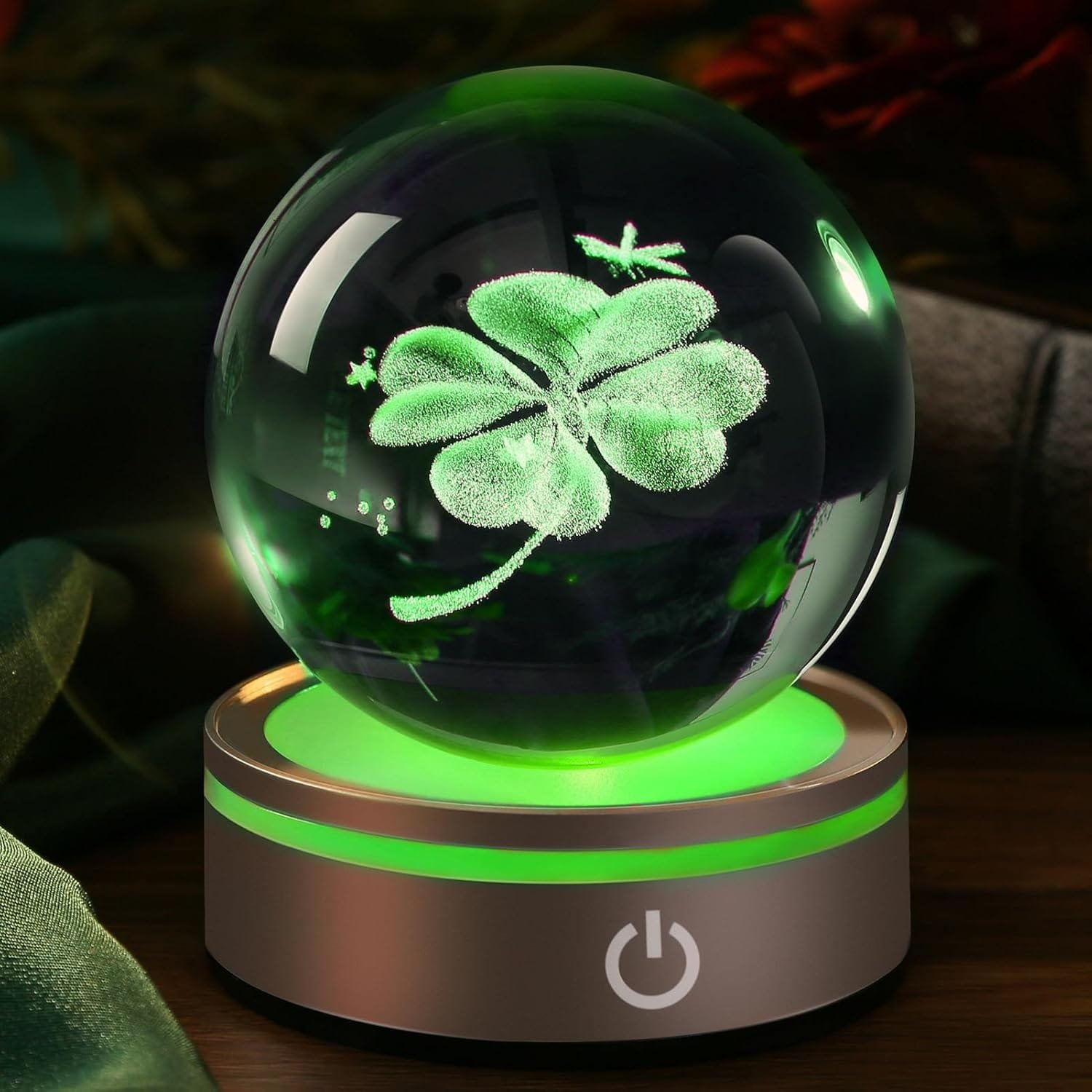 A glowing glass orb with a 3D holographic clover design, set on an illuminated base with a power symbol.