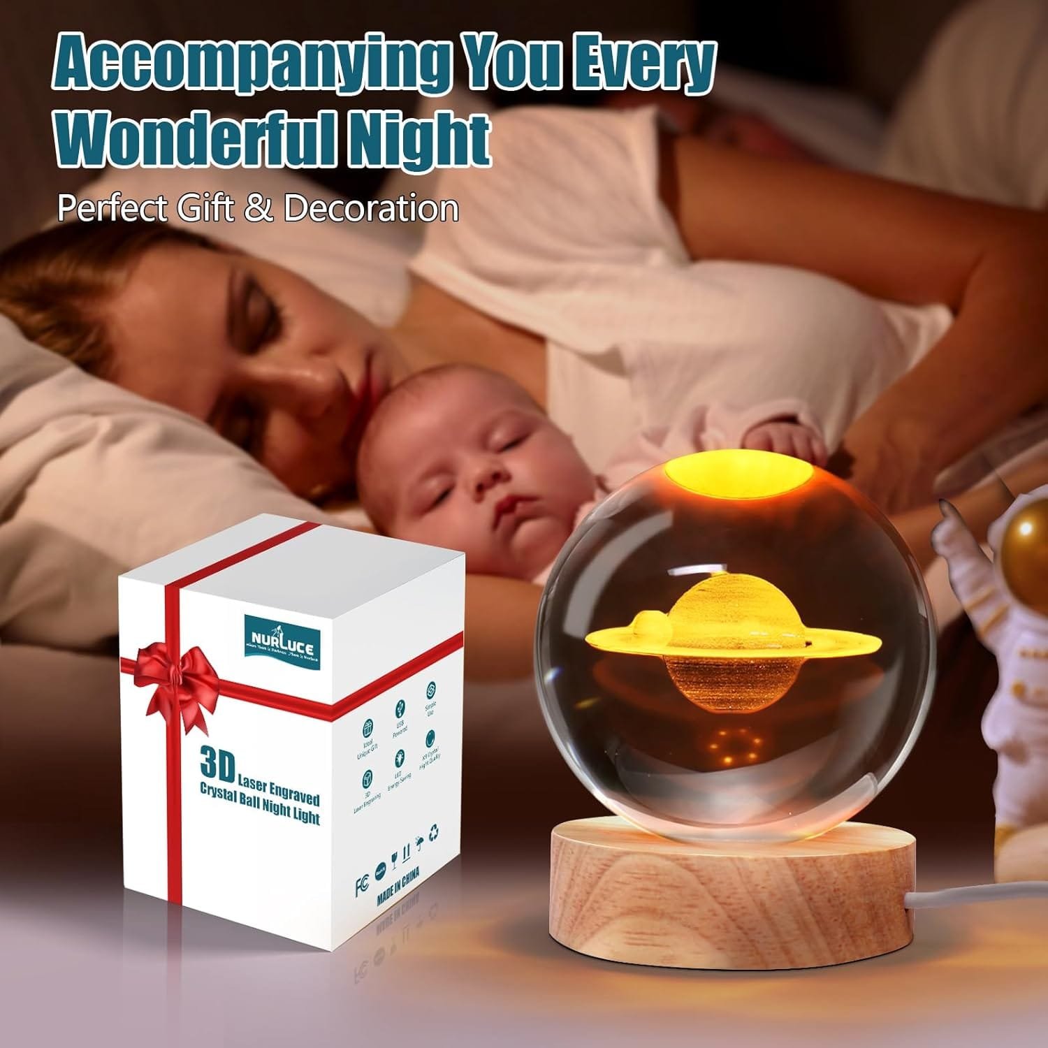 A sleeping woman and baby with a decorative Saturn-themed night light. Beside them is the product box labeled "3D Laser Engraved Crystal Ball Night Light.