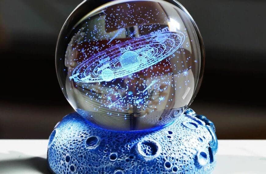 A glass orb displays a holographic model of a solar system, resting on a textured, blue, moon-like base.