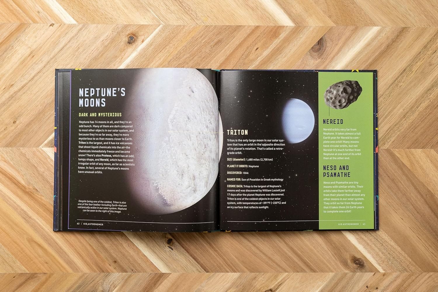 An open book on a wooden surface showing pages about Neptune's moons, including Triton, and information on Nereid, Ness, and Psamathe with images of a moon and an asteroid.