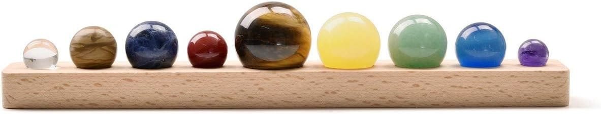 A wooden base holds a row of nine spherical stones of varying sizes and colors, including clear, red, brown, yellow, green, blue, and purple.