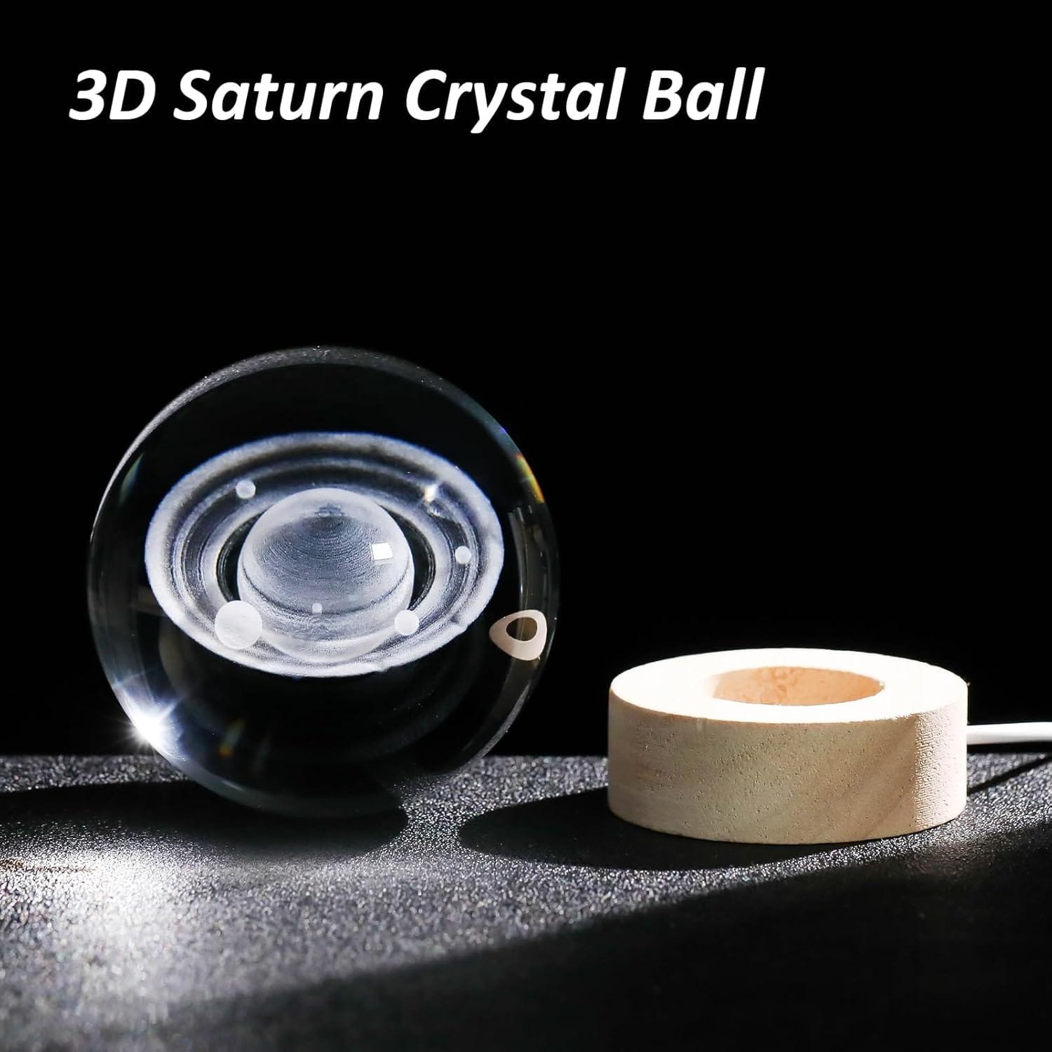 3D crystal ball depicting Saturn placed next to a wooden LED base on a dark surface.