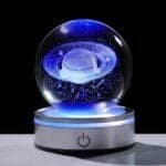A glowing crystal ball with a 3D galaxy design sits on an illuminated base with a power symbol, set against a black background.