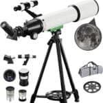 Telescope setup with a tripod, three lenses, a moon image inset, carrying case, and star map.