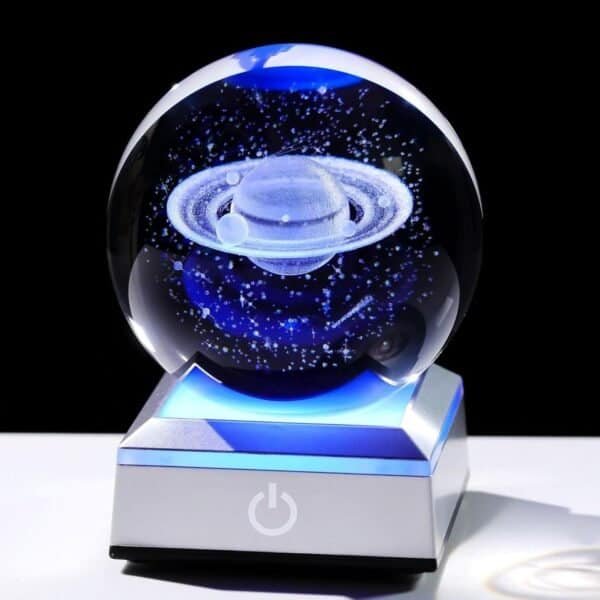 Crystal ball with a 3D laser-etched Saturn, illuminated on a lit square base with a power symbol.