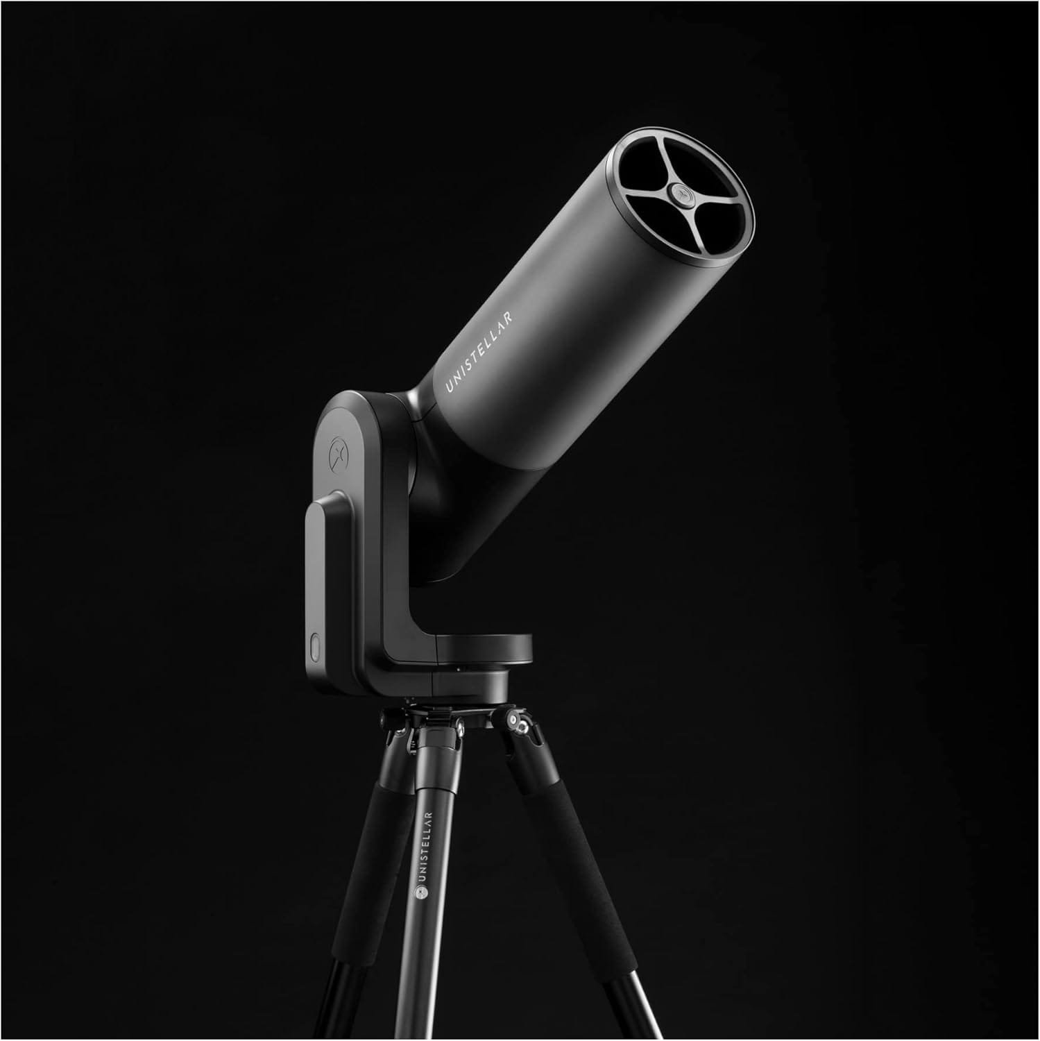 A black telescope on a tripod is set against a dark background.