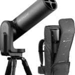 A black telescope on a tripod next to a matching black backpack case.
