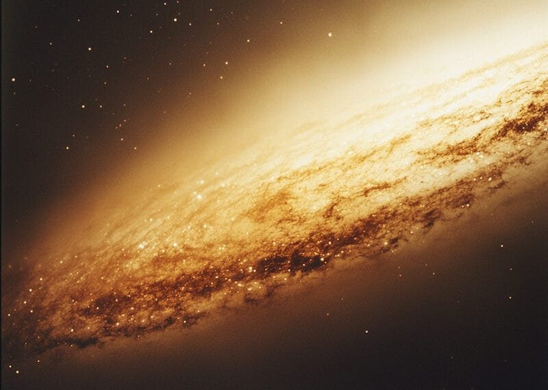An image of a spiral galaxy with a bright core, surrounded by dust and stars, graces the dark space background, reminiscent of the breathtaking sights that Voyager 1 captures on its cosmic journey.