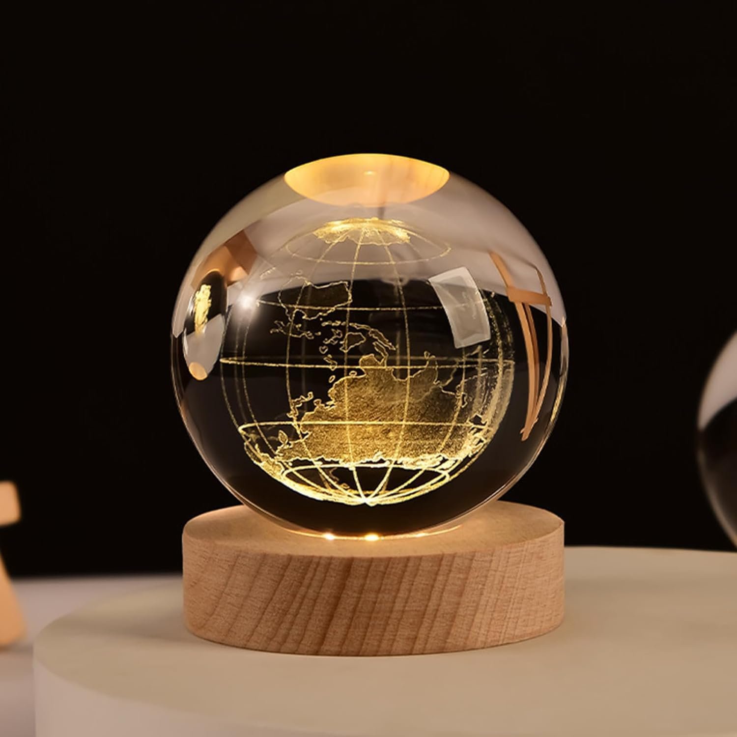 A glowing glass sphere with an etched map of the Earth rests on a wooden base. The background is dark, highlighting the illuminated globe.