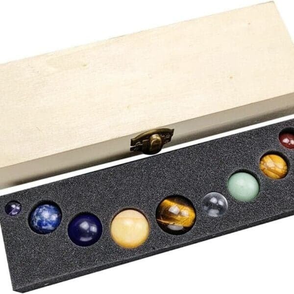 A wooden box with a hinged lid is open, revealing nine spherical stones of various colors resting in a foam insert.