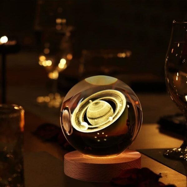 A glowing crystal ball with an image of Saturn sits on a wooden base, surrounded by dimly lit glassware.