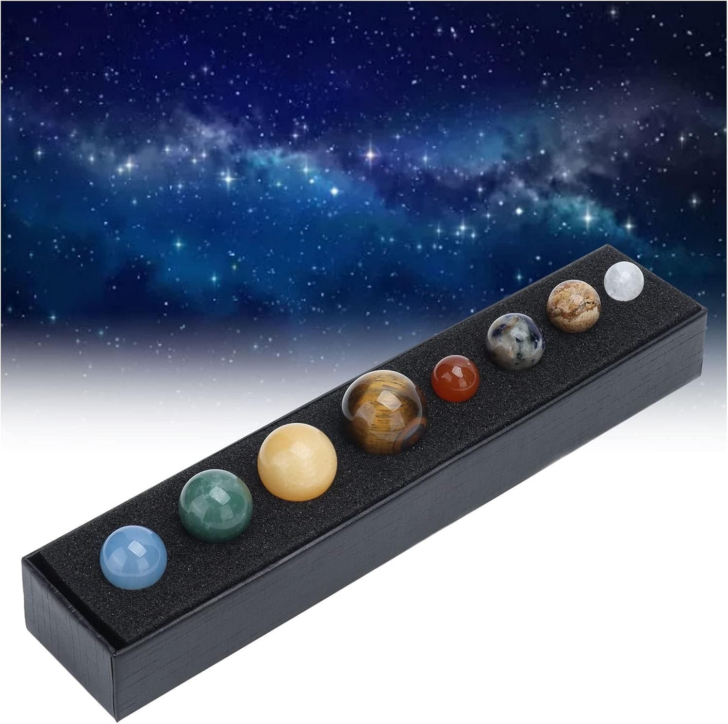 A display set of eight decorative stone spheres arranged in a black box against a starry sky background.