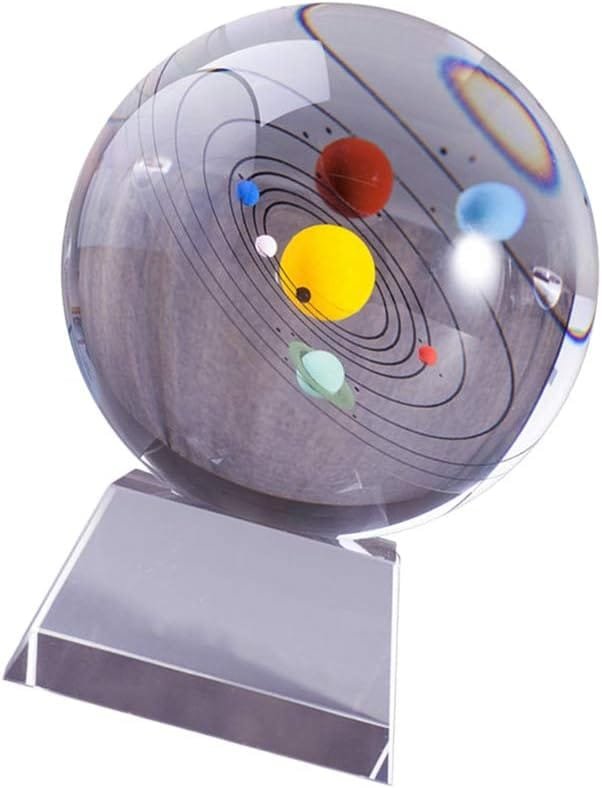 Glass sphere displaying a model of the solar system, showing planets in orbit on a clear stand.