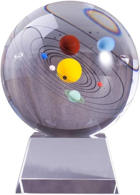 A glass sphere with a miniature solar system model inside, showing planets orbiting a central sun on a clear stand.