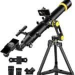 A black telescope on a tripod with adjustable components, a smartphone adapter, and additional lenses.