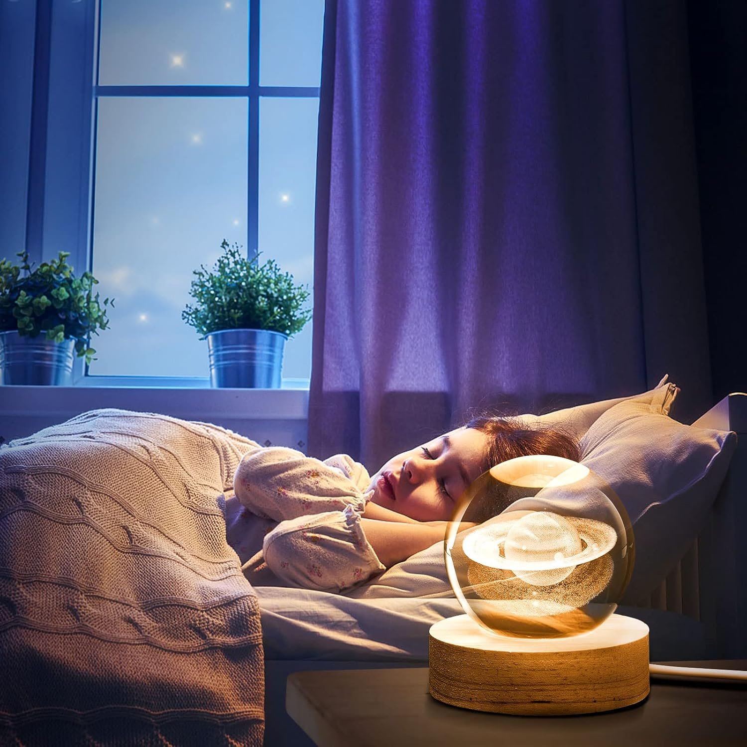 A person sleeping in bed with a glowing Saturn-shaped lamp on the bedside table.