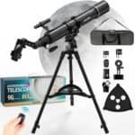 Astronomical telescope with tripod, moon in background. Includes accessories: smartphone adapter, finder scope, two eyepieces, barlow lens, wireless remote, carrying case, and a manual.