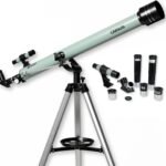 A silver Carson telescope mounted on a tripod, shown with interchangeable eyepieces and accessories arranged beside it.