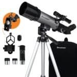 Celestron telescope kit with tripod, two eyepieces, smartphone adapter, 3x Barlow lens, finder scope, and carrying case displayed against a white background.