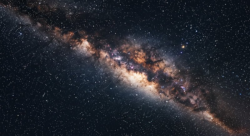 Exploring the Milky Way Galaxy 5 A detailed view of the Milky Way galaxy showing a dense band of stars, dust, and clouds stretching diagonally across a dark night sky.