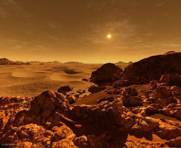 From Which Planet Can We Have a Better View of the Sun? 5 Rocky, barren landscape under an orange sky with distant mountains and a setting sun, resembling the surface of another planet.