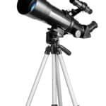 A black and silver telescope mounted on a tripod, with an attached small finder scope and adjustment knobs visible.