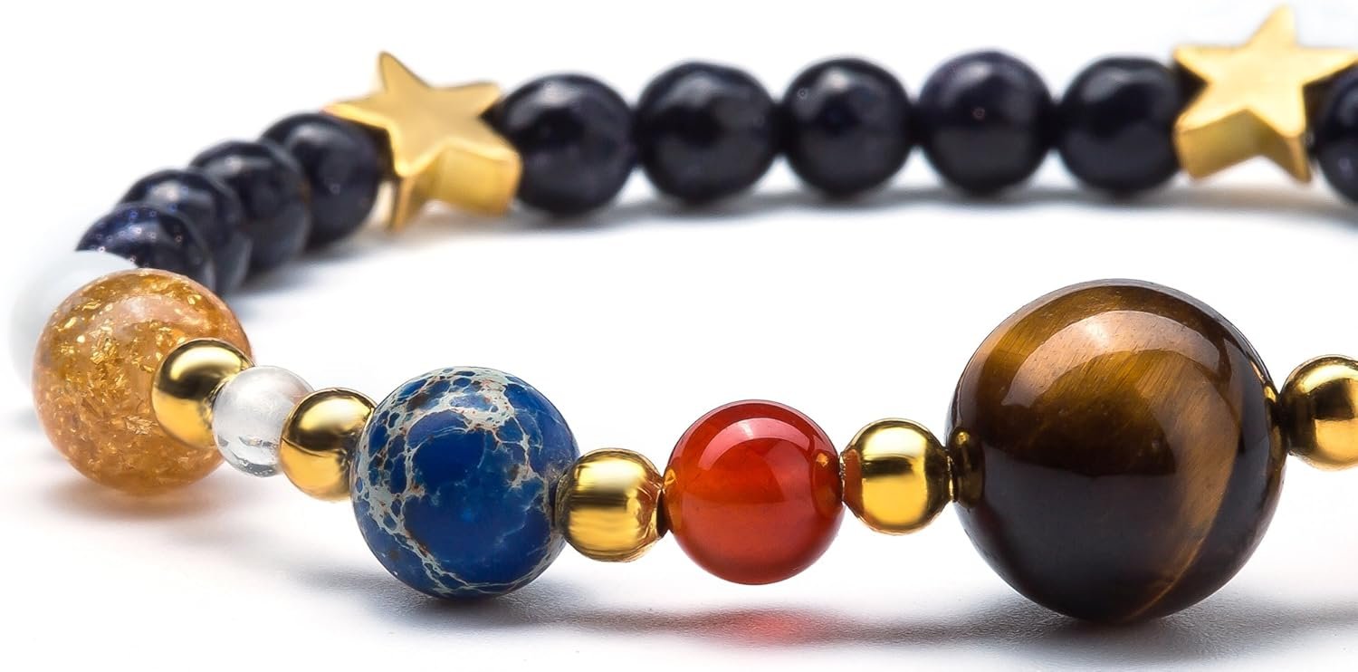 Close-up of a beaded bracelet featuring round stones in various colors, gold accents, and gold star-shaped beads on a white background.