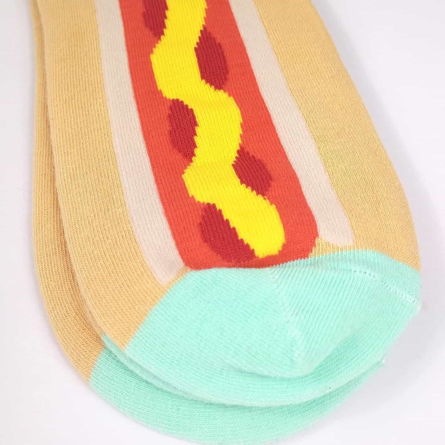 A pair of socks designed to look like a hot dog with mustard, featuring beige, red, yellow, and light blue colors.