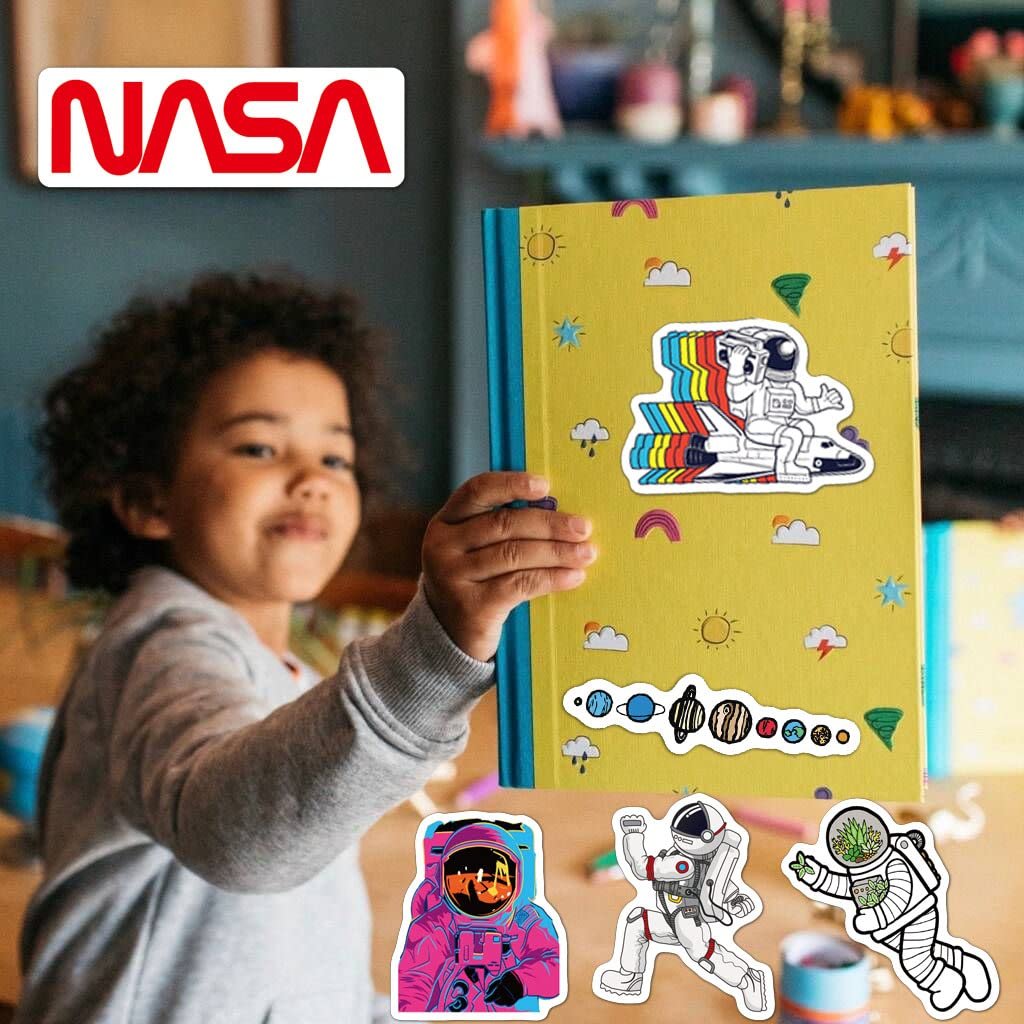 A child holds up a yellow notebook decorated with colorful space-themed astronaut and planet stickers; a NASA logo appears in the top left corner.