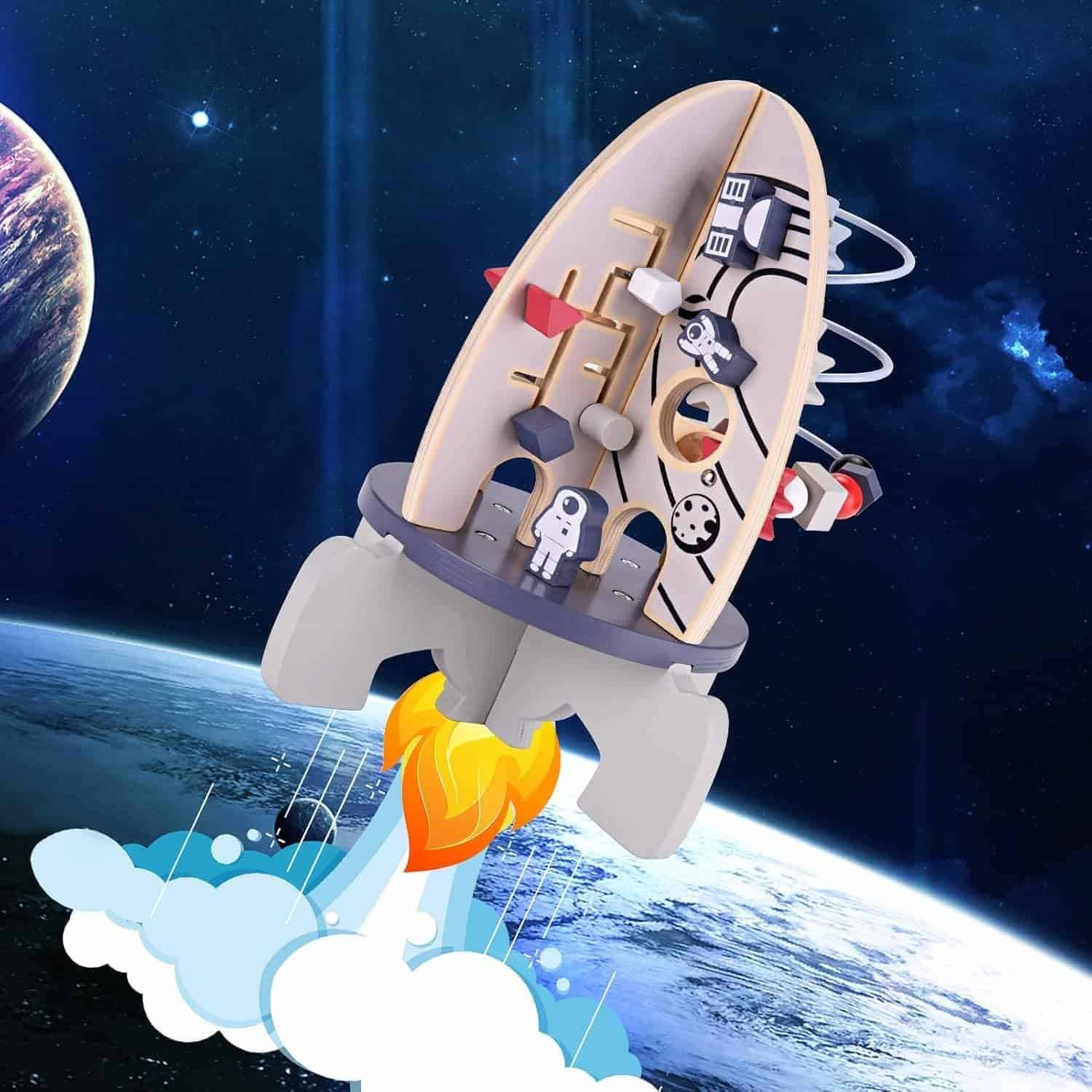 A toy wooden rocket ship with space-themed decorations launches into space, with planets and stars visible in the background.