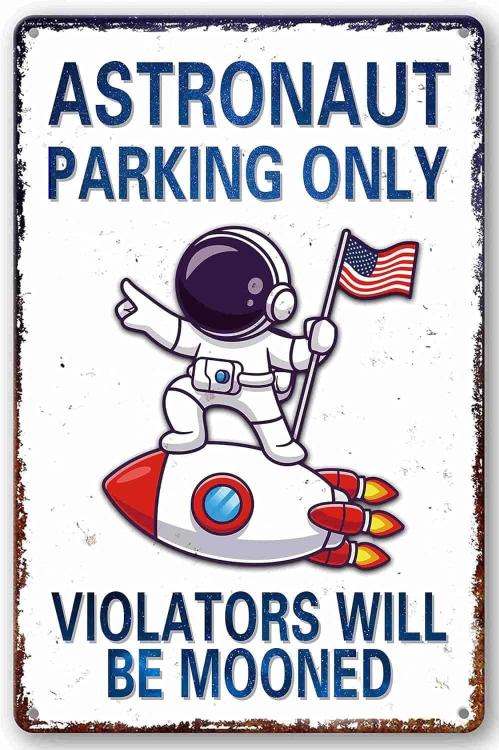 A sign reads "Astronaut Parking Only, Violators Will Be Mooned," with a cartoon astronaut holding an American flag and standing on a rocket.
