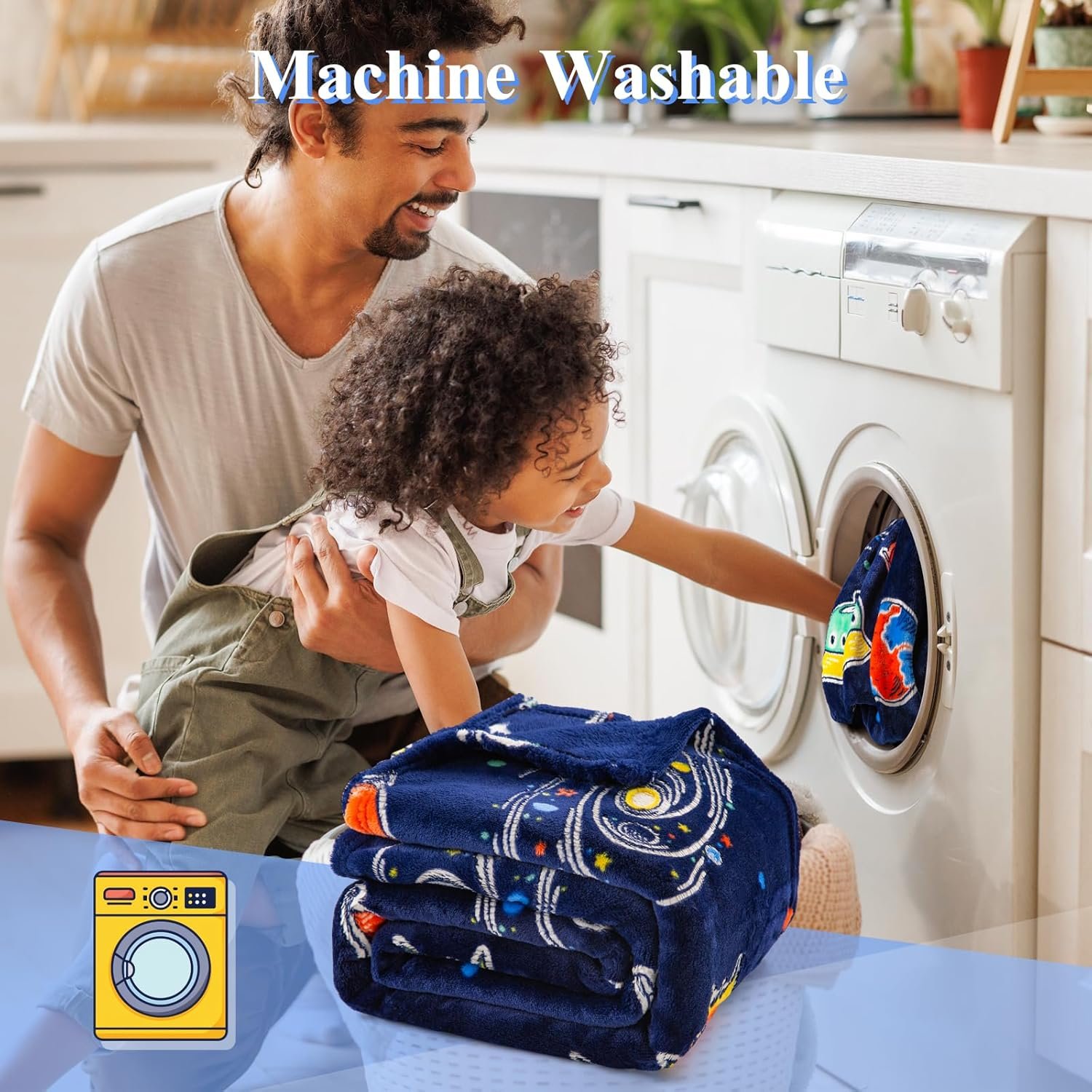An adult and a child load a washing machine with a dark blue blanket featuring a space design; another blanket is folded in front of them. Text reads "Machine Washable.