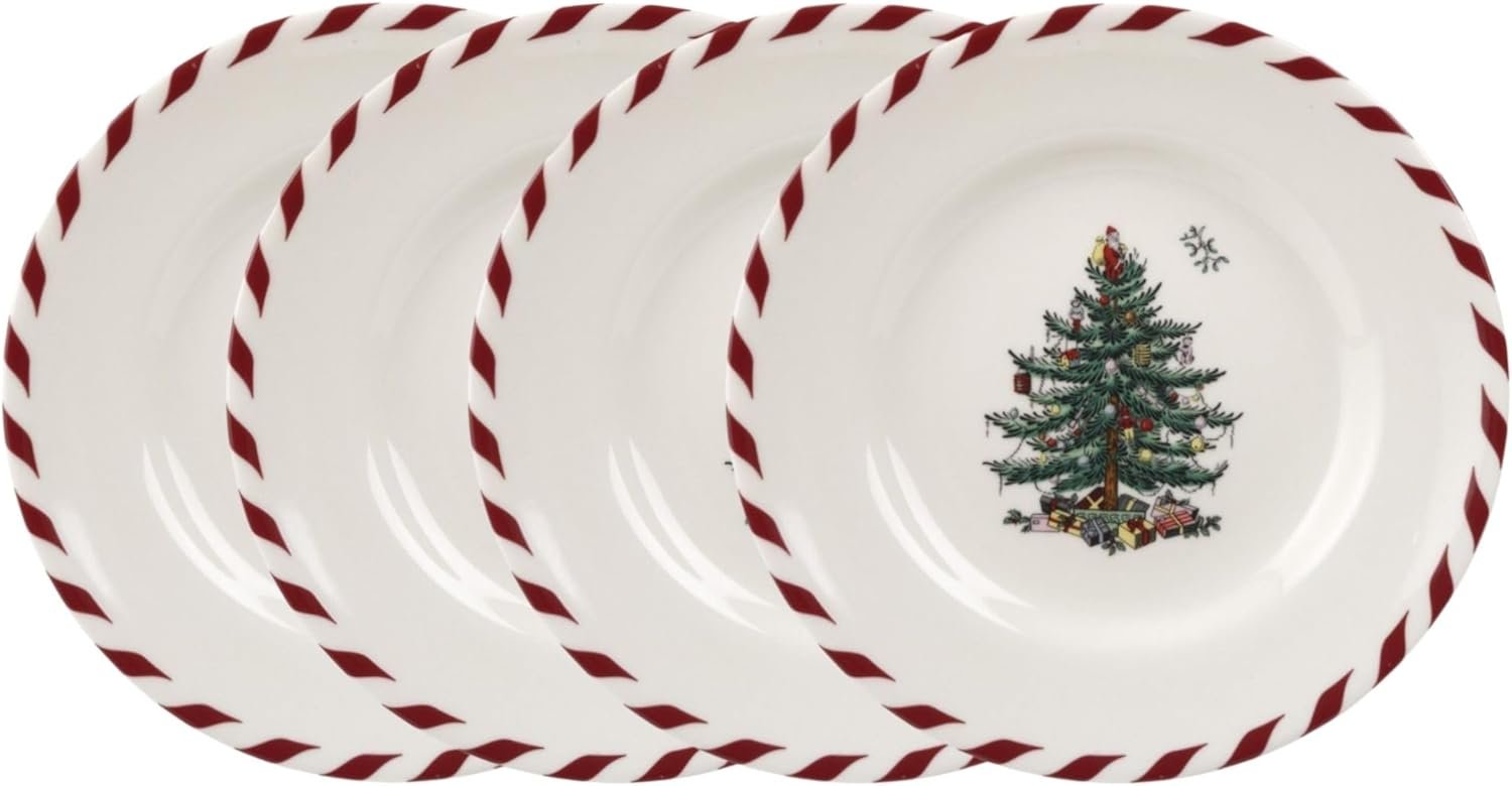 Four white plates with red and white striped rims, each featuring a decorated Christmas tree with gifts at the center.