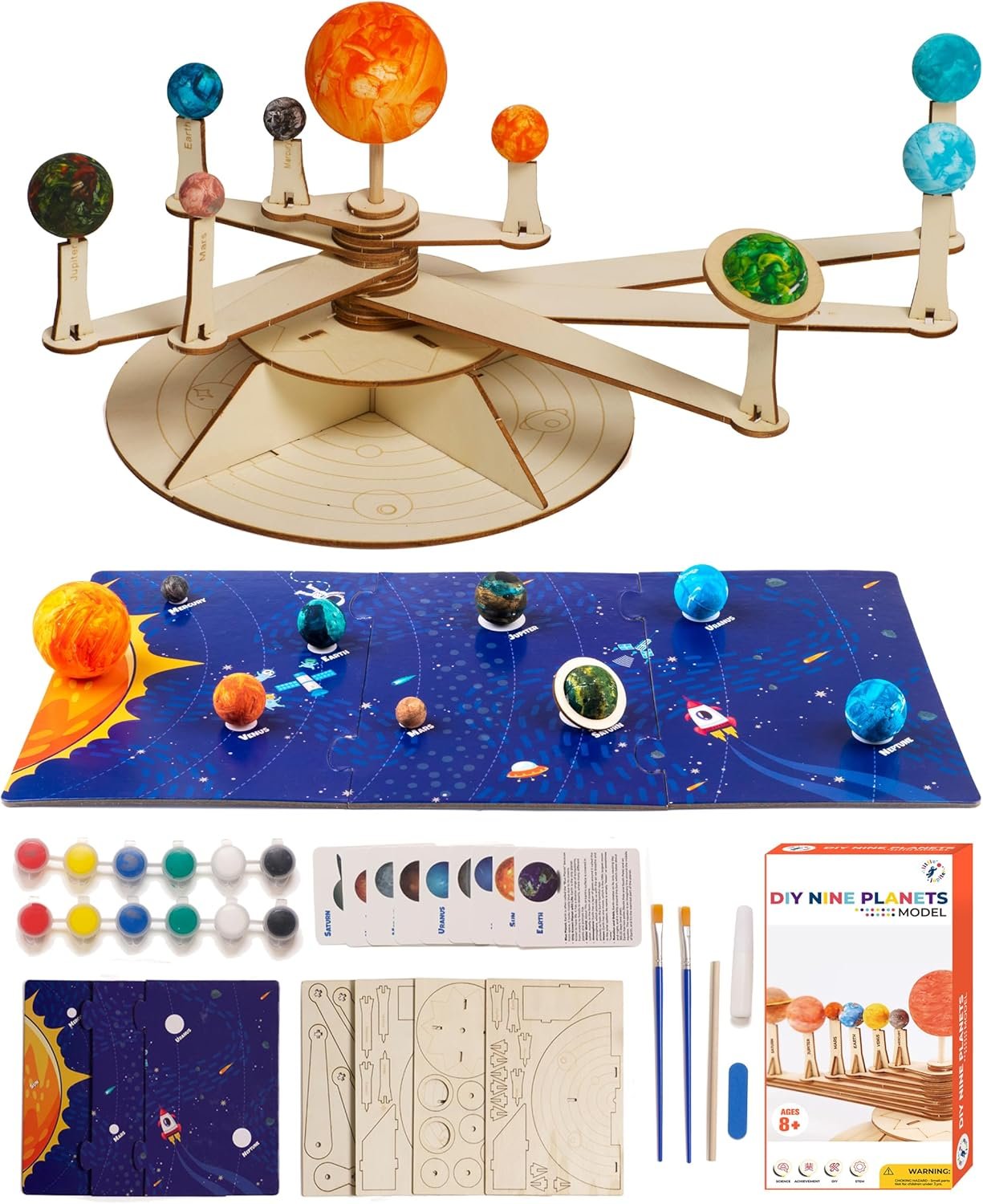 A DIY solar system model kit is shown with painted planet spheres, wooden assembly parts, a blue solar system mat, paint pots, brushes, instruction cards, and the box displaying the finished model.