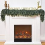 A white fireplace with a faux fire, decorated with green garland, gold nutcrackers, a gold reindeer, and "MERRY CHRISTMAS" letters on the mantel.