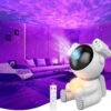 A small astronaut-shaped night light projects purple galaxy patterns onto the ceiling of a modern living room; a remote control is placed in front of the light.