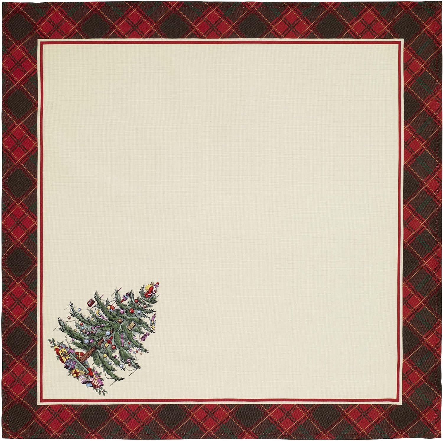 A square cream-colored tablecloth with a red and black plaid border and a decorated Christmas tree in one corner.