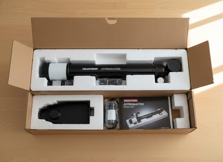 A Celestron AstroMaster telescope and accessories are neatly packed in a cardboard box with foam inserts, alongside an instruction manual for effortless telescope setup.