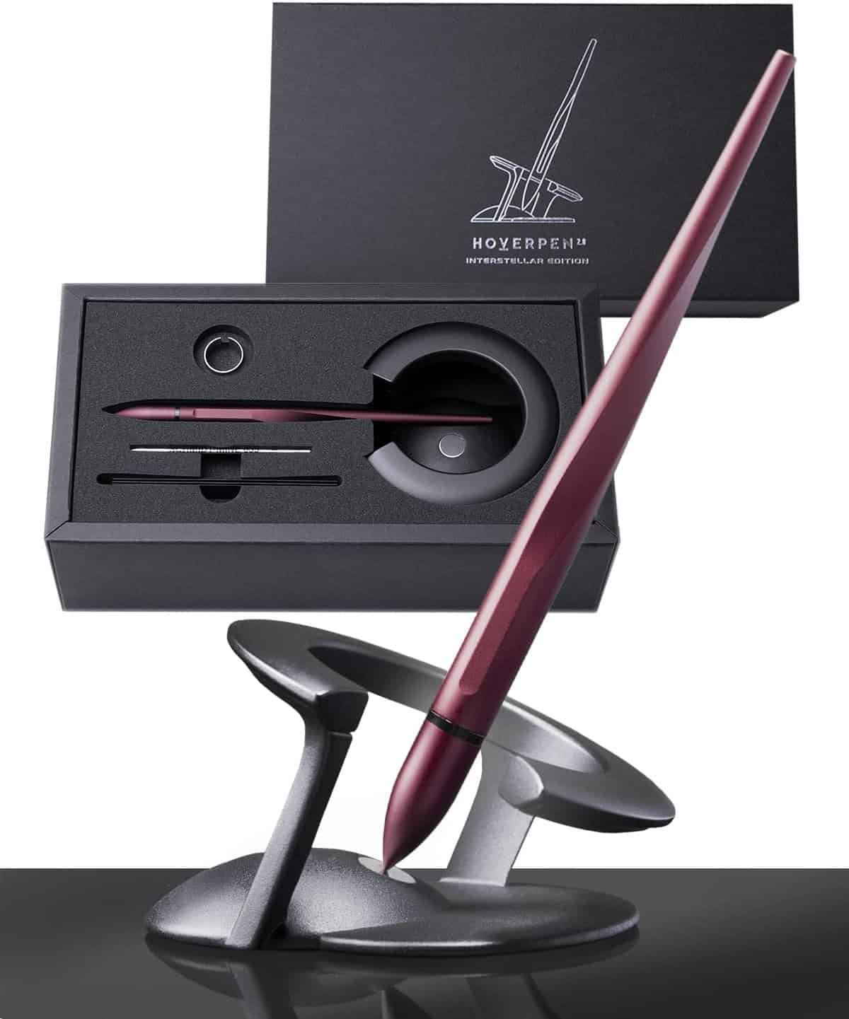 A sleek metallic pen in a modern desk stand, with its packaging and box showing an outlined pen design and the label “HOVERPEN Interstellar Edition.”.