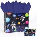 Gift bag with a space theme design, featuring colorful planets, stars, and two astronauts floating; matching card and dark blue tissue paper included.