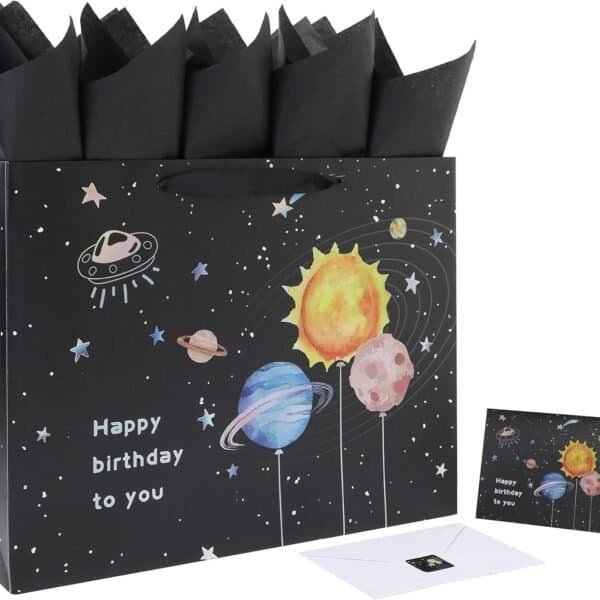 A black gift bag with a space-themed design and "Happy birthday to you" text, black tissue paper, and a matching birthday card with envelope.